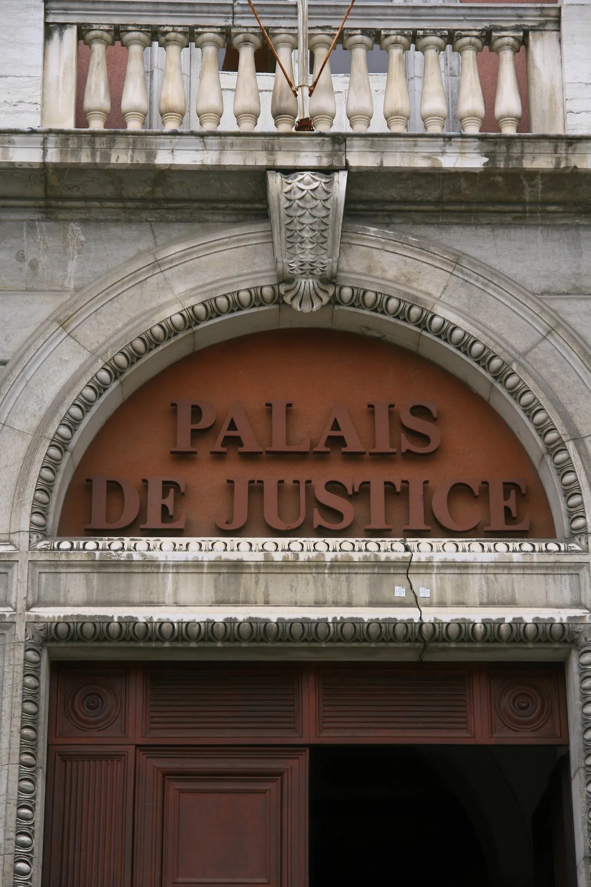 Portail d'entrée du Palais de Justice, représentant l'engagement dans les affaires de droit public. 